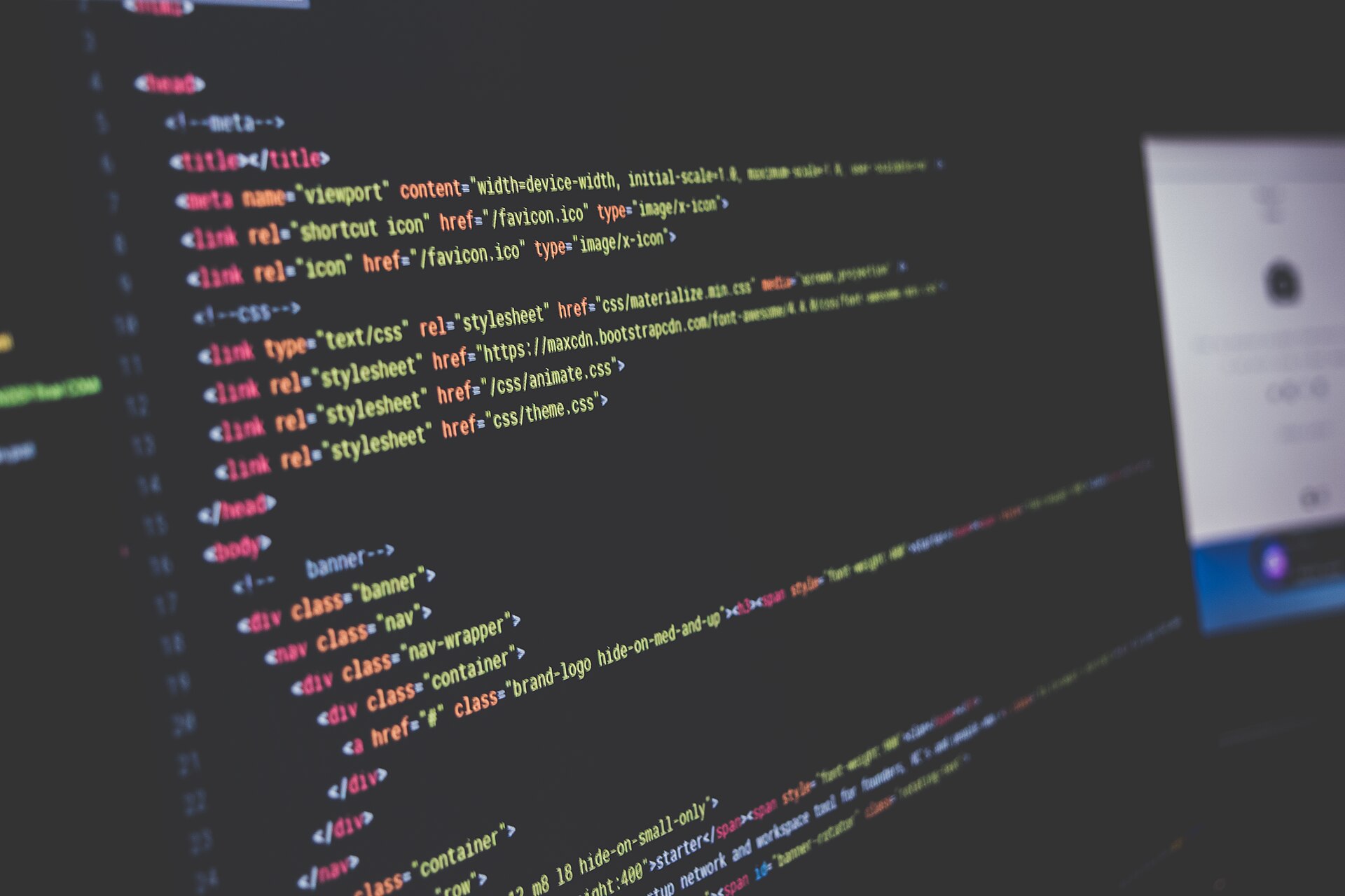 Kode på en skærm i mørke, håndskreven HTML og CSS som baggrund for ejerskab af koden